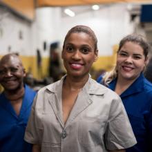 Group of smiling female mechanics in an auto repair shop 