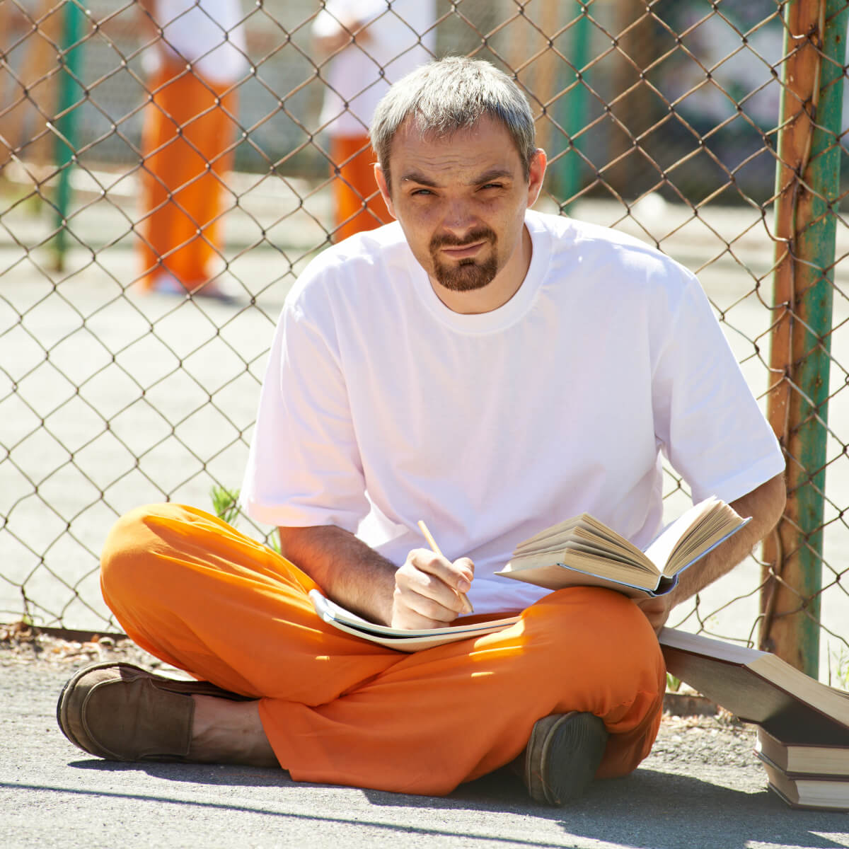 Prisonnier assis et prenant des notes