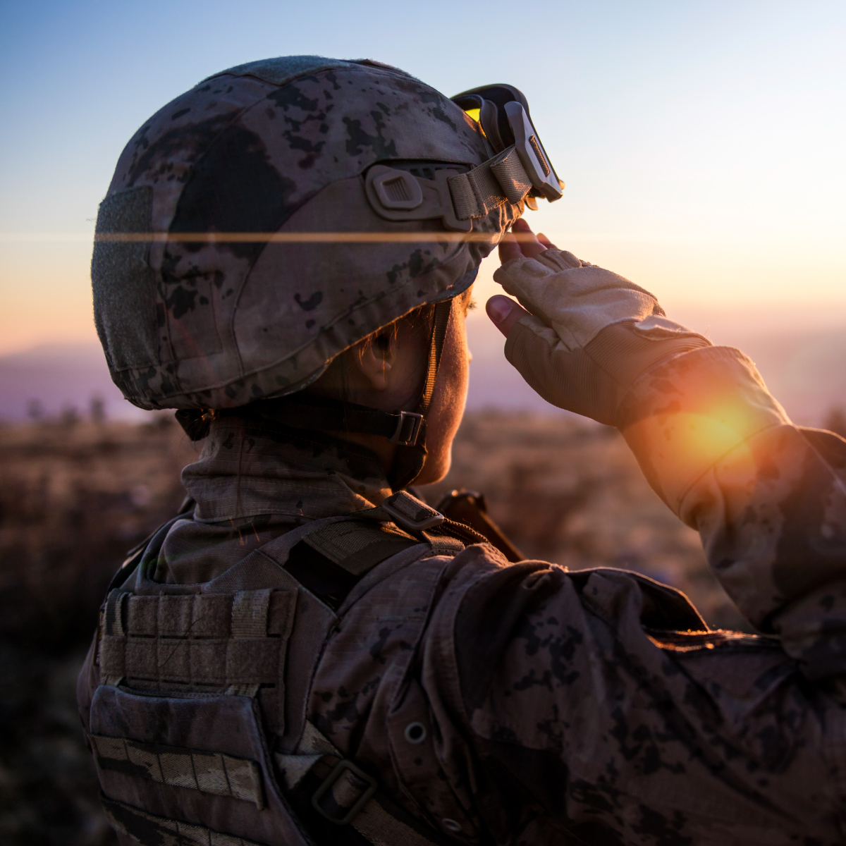 Un soldat regarde un couché de soleil à l'horizon