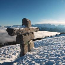 Large Inukshuk on a snowy mountain slope