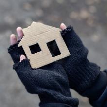 two hands holding a house in paper 